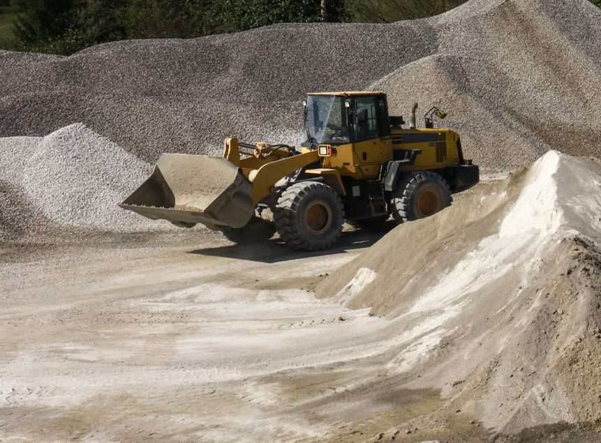 Contractors Resource | Early Branch, SC | Yellow bobcat driving through a quarry with sand and stone